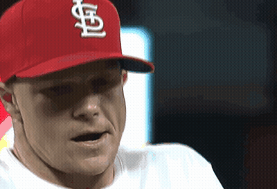 A Man Wearing A Red Cardinals Hat Looks To His Left GIF