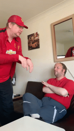 A Man Wearing A Red Chevrolet Shirt Is Talking To Another Man In A Red Shirt GIF