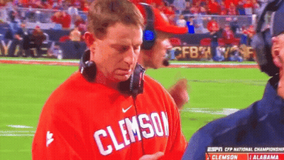 A Man Wearing A Red Clemson Shirt Stands On A Field GIF