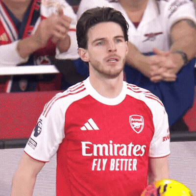 A Man Wearing A Red Emirates Fly Better Jersey Holds A Soccer Ball GIF