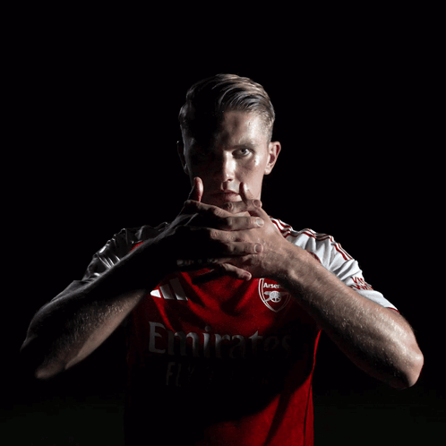 A Man Wearing A Red Emirates Jersey Holds His Hands To His Face GIF