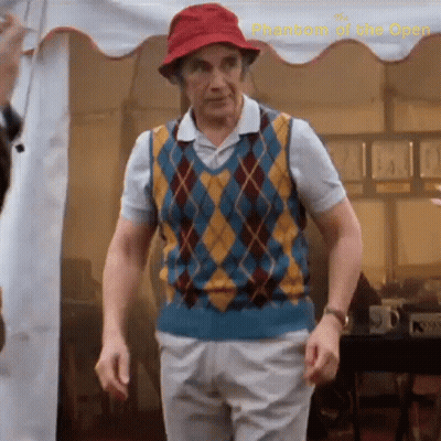 a man wearing a red hat and a plaid vest is standing in front of a white tent ..