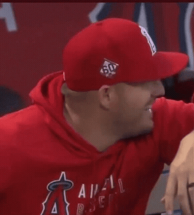 A Man Wearing A Red Hat And A Red Hoodie Is Smiling . GIF