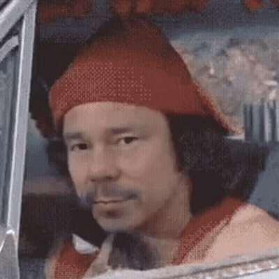 A Man Wearing A Red Hat And A Red Shirt Is Sitting In The Driver 'S Seat Of A Car . GIF