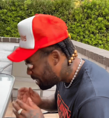 A Man Wearing A Red Hat And A T-Shirt That Says Calvin Klein On It GIF