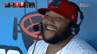A Man Wearing A Red Hat And Headphones Is Laughing GIF