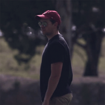 A Man Wearing A Red Hat And Sunglasses Stands In A Field GIF