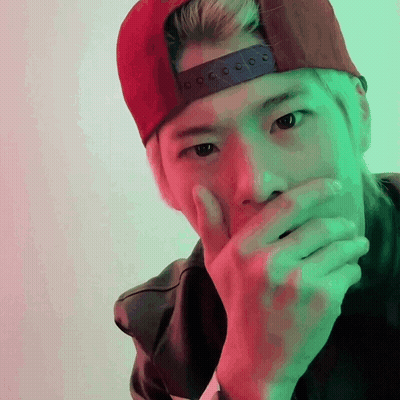 A Man Wearing A Red Hat Covering His Mouth GIF