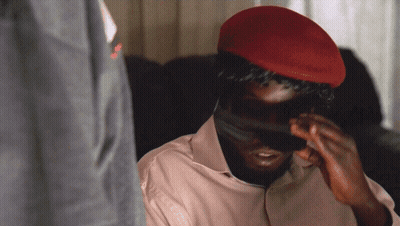 A Man Wearing A Red Hat Is Covering His Face With His Hands GIF