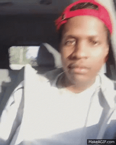 A Man Wearing A Red Hat Is Sitting In The Back Seat Of A Car GIF