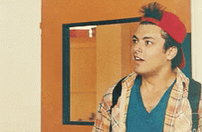 A Man Wearing A Red Hat Is Standing In Front Of A Door . GIF