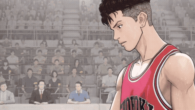 A Man Wearing A Red Hawks Jersey Stands In Front Of A Crowd Of People GIF