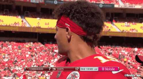 A Man Wearing A Red Headband Stands In Front Of A T Mobile Banner GIF