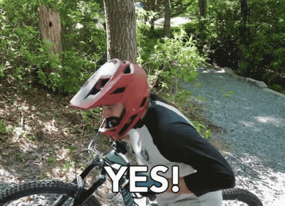 A Man Wearing A Red Helmet Is Riding A Bike And Says " Yes " In White Letters GIF