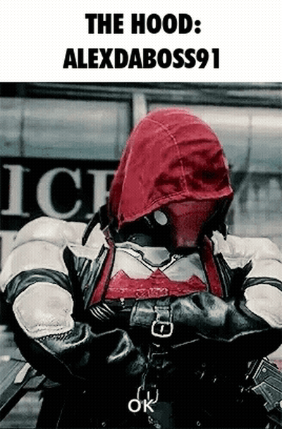 A Man Wearing A Red Hood Is Standing In Front Of A Building . GIF
