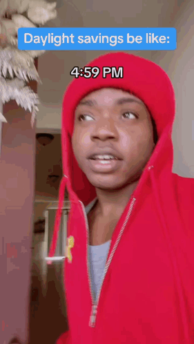 A Man Wearing A Red Hoodie And A Red Hat Says Daylight Savings Be Like At 4:59 Pm GIF