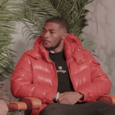 A Man Wearing A Red Jacket And A Balenciaga Shirt GIF