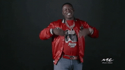 A Man Wearing A Red Jacket And A Heavy Camp Shirt Is Standing In Front Of A Black Background . GIF