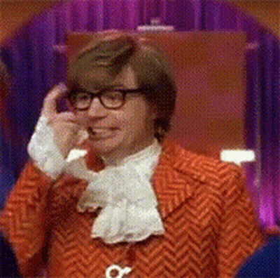 A Man Wearing A Red Jacket And Glasses Is Talking On A Cell Phone GIF