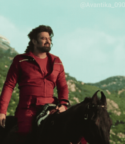A Man Wearing A Red Jacket Is Riding A Black Horse GIF