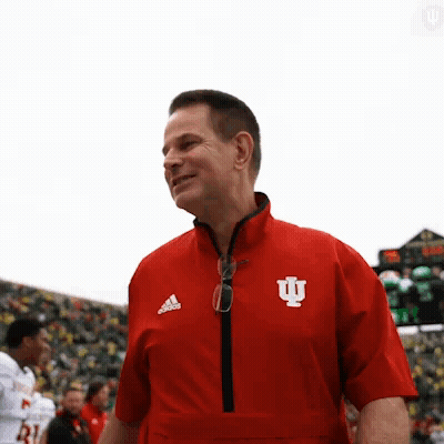 A Man Wearing A Red Jacket With The Letter I On The Front GIF