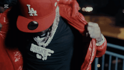 A Man Wearing A Red La Hat And A Black Shirt GIF