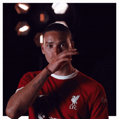 A Man Wearing A Red Lfc Shirt Is Covering His Face With His Hand GIF