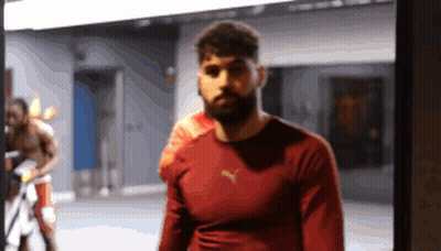 A Man Wearing A Red Puma Shirt Stands In A Gym GIF