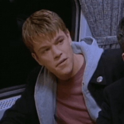 A Man Wearing A Red Shirt And A Black Jacket Is Looking At Something GIF
