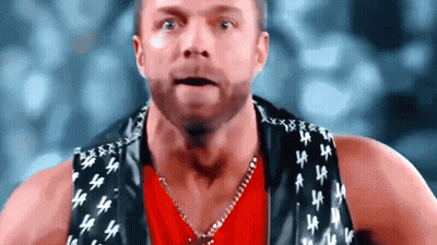 A Man Wearing A Red Shirt And A Black Vest With La Letters On It GIF
