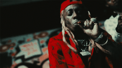 A Man Wearing A Red Shirt And A Red Hat Is Smoking A Cigarette GIF
