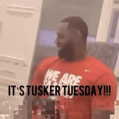 A Man Wearing A Red Shirt That Says It 'S Tusker Tuesday . GIF