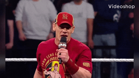 A Man Wearing A Red Shirt That Says John Cena On It Is Holding A Microphone GIF