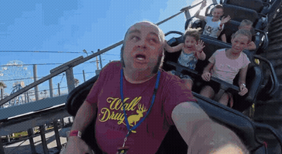 A Man Wearing A Red Shirt That Says Wall Drug Is Riding A Roller Coaster GIF