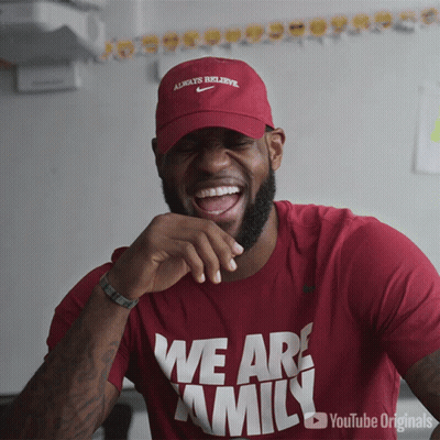 A Man Wearing A Red Shirt That Says We Are Family Is Laughing GIF