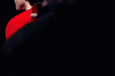 A Man Wearing A Red Shirt With Expedia Written On The Sleeve GIF