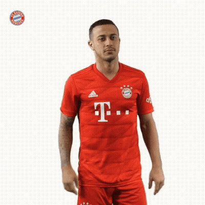 A Man Wearing A Red Shirt With The Bayern Munich Logo On The Front GIF