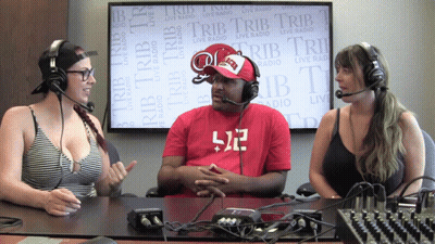 A Man Wearing A Red Shirt With The Number 512 On It Sits Between Two Women GIF