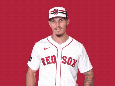 A Man Wearing A Red Sox Jersey Is Waving His Hands In The Air GIF