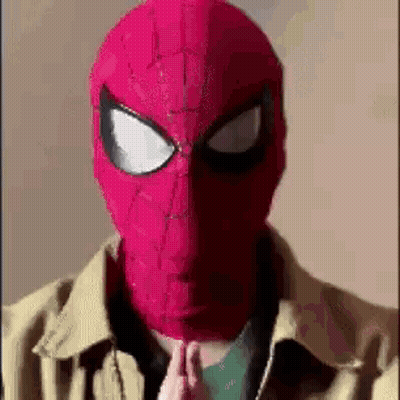 A Man Wearing A Red Spider-Man Mask And A Jacket Is Praying . GIF
