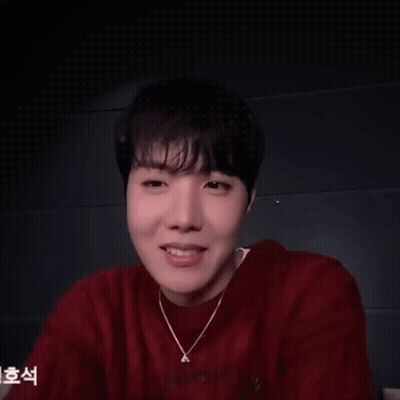 A Man Wearing A Red Sweater And A Necklace With The Letter A On It GIF