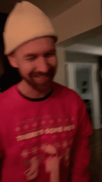 A Man Wearing A Red Sweater That Says There 'S Some Hos On It GIF