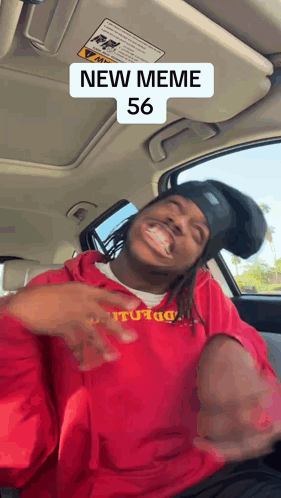 A Man Wearing A Red Sweatshirt With The Number 56 On It Is Sitting In A Car GIF