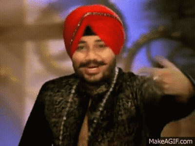 A Man Wearing A Red Turban And A Black Jacket Is Making A Funny Face . GIF