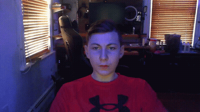 A Man Wearing A Red Under Armour Shirt Is Looking At The Camera GIF