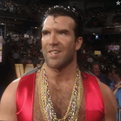 A Man Wearing A Red Vest And Gold Chains Smiles GIF