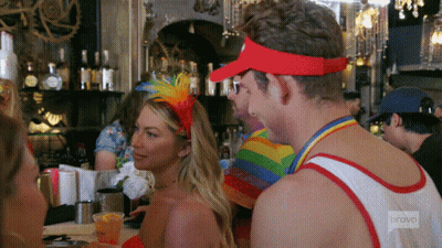 A Man Wearing A Red Visor Is Talking To A Woman In A Red Dress GIF