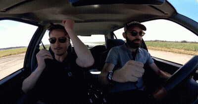 A Man Wearing A Reebok Hat Sits In A Car With Another Man GIF