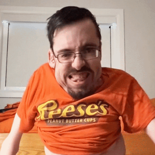 A Man Wearing A Reese 'S Peanut Butter Cups Shirt GIF