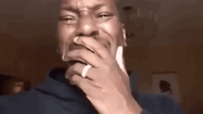 A Man Wearing A Ring On His Finger Is Covering His Mouth With His Hand . GIF